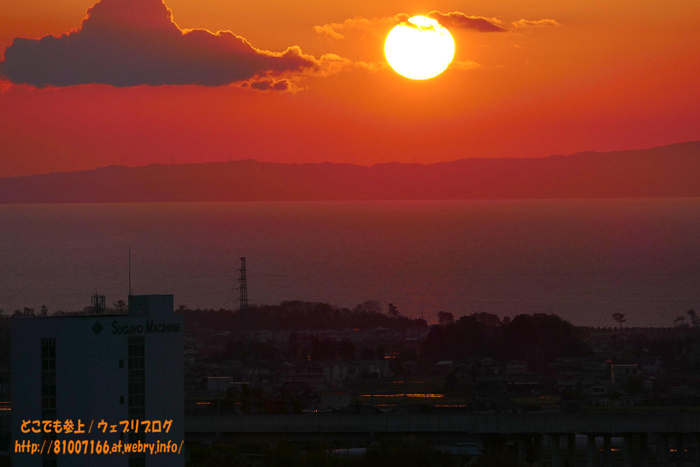 富山湾に沈む夕日が、色付けた”芝桜”と蜃気楼の層らしきものを